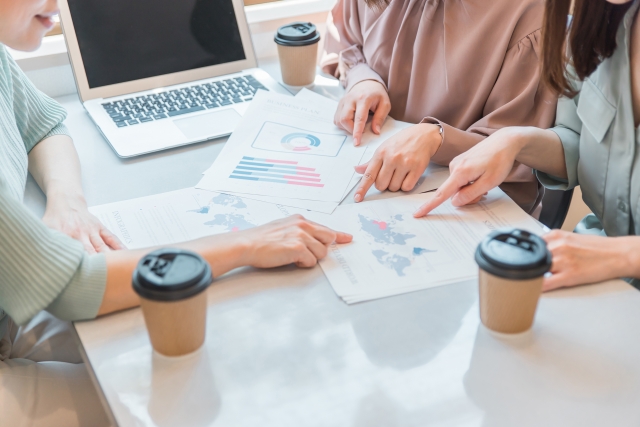 資料を見て相談する３人組